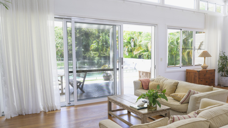 Interior of contemporary home with sheer curtains over sliding glass doors.