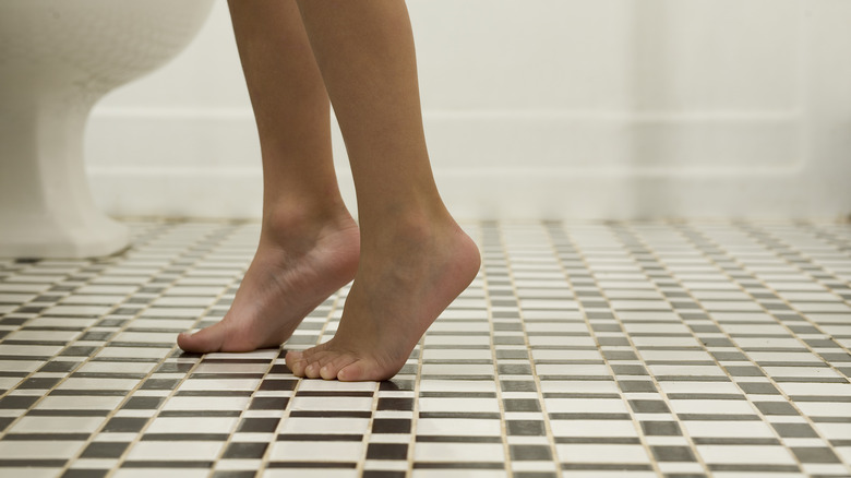 Woman standing on bathroom floor