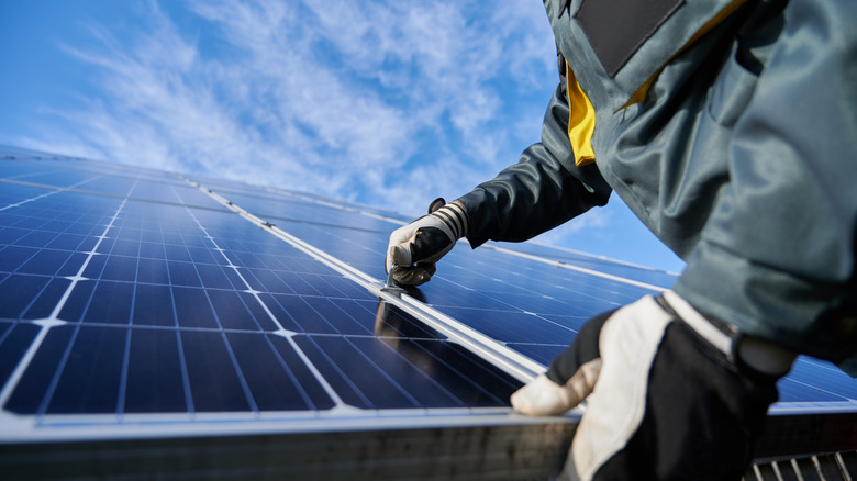 Hands installing solar panels