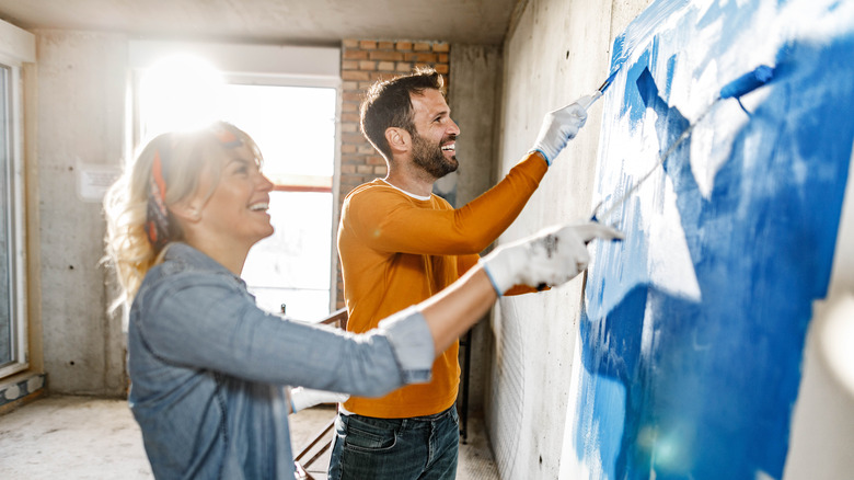 Couple painting wall blue