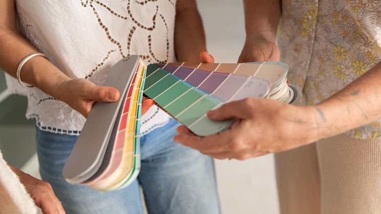 Close-up of two people looking at paint color samples