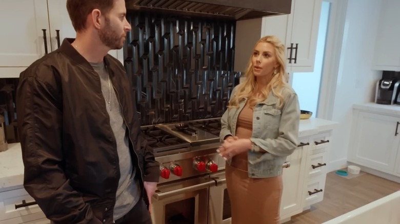 Tarek and Heather Rae El Moussa in their kitchen featuring black geometric backsplash