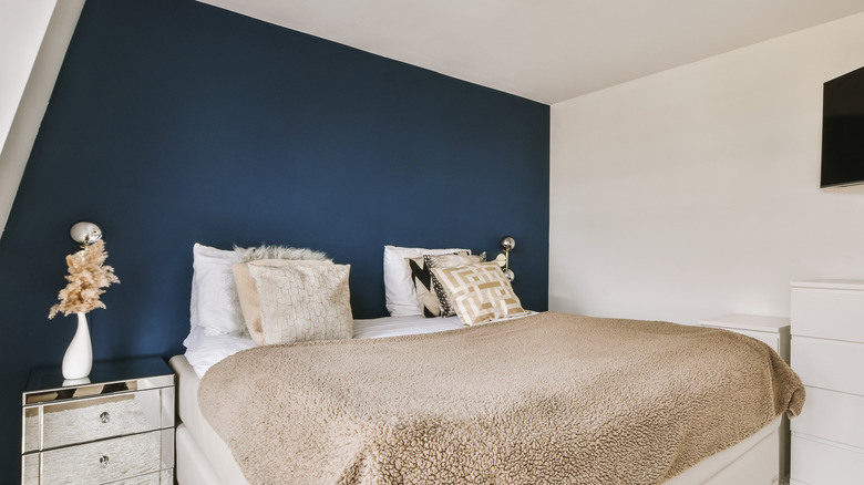 small bedroom with navy blue accent wall