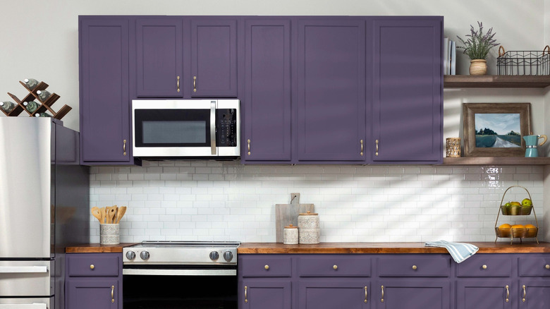 A kitchen with aubergine cabinets