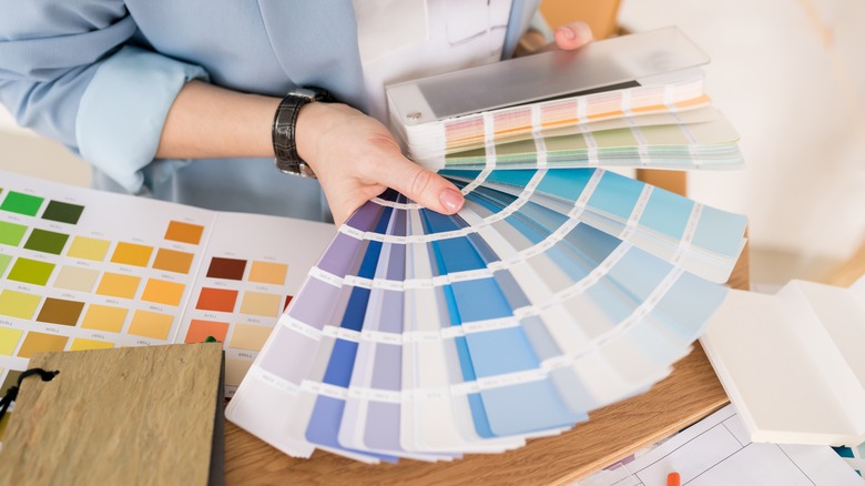 A person selecting paint colors from swatches