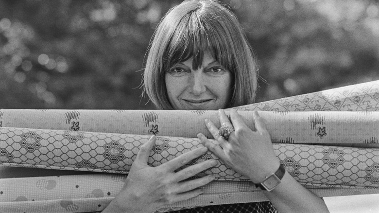Woman holding wallpaper rolls