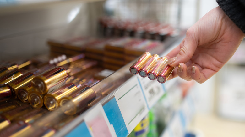 A shopper inspecting a pack of batteries.