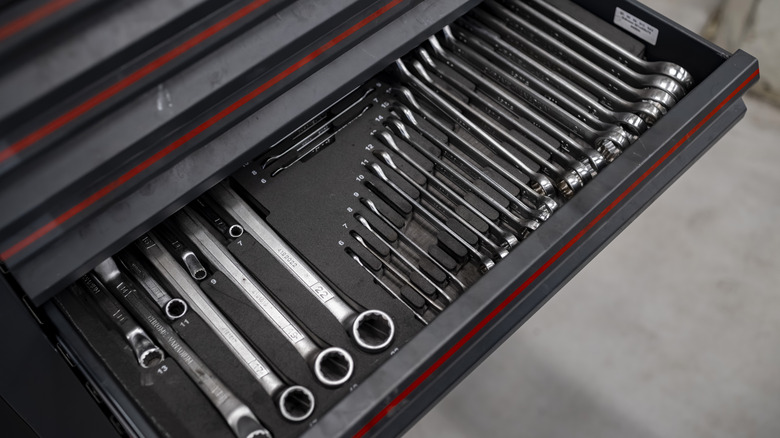 Professional tool drawer containing organized wrenches and socket sets in foam insert storage system.