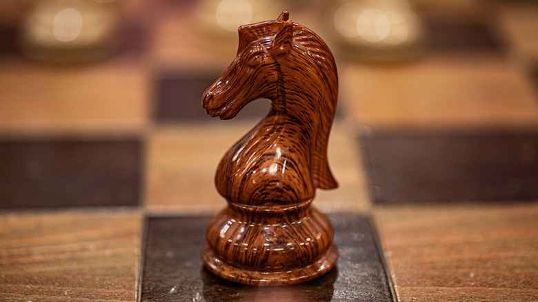 A chessboard with a carved knight piece in the center