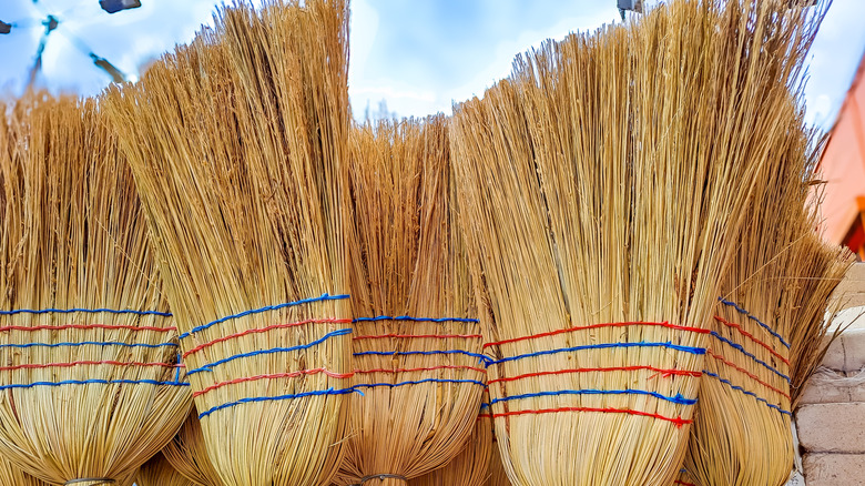 broom heads lined up outdoors