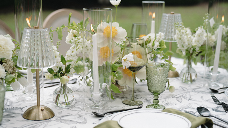 A table centerpiece with flowers, candles, and lighting.