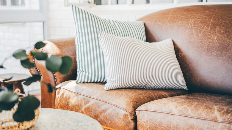 worn-in leather couch with striped pillows