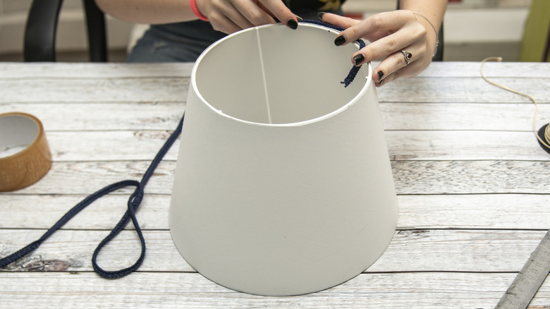 A person works on a DIY lampshade project