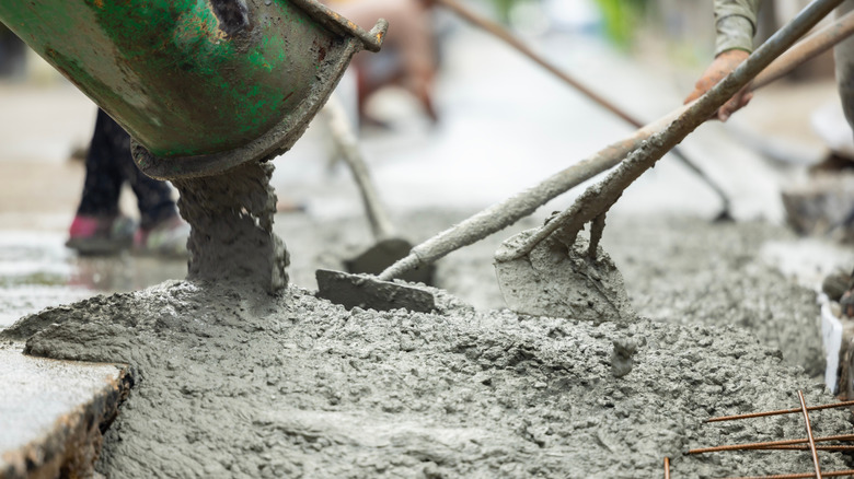 Concrete is being poured into a mold that's lined with rebar.