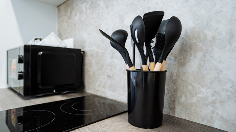 a black utensil holder in a modern kitchen