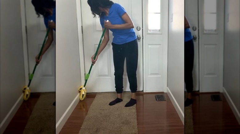 Woman cleaning baseboards with broom hack