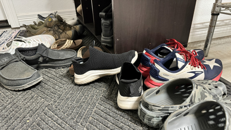 An entryway floor cluttered with shoes.