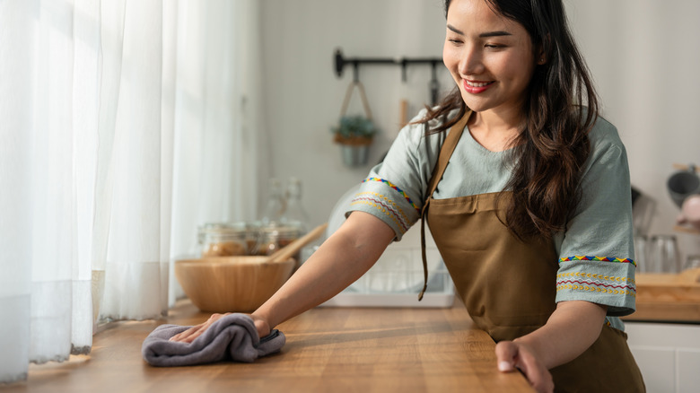 Woman wiping countertop with cloth