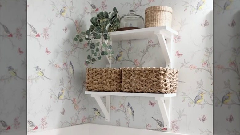 IKEA TRANHULT shelf in bathroom on top of bird wallpaper.