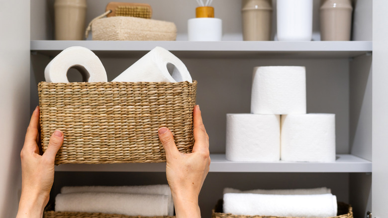 Rolls of toilet paper are stored in a woven basket.