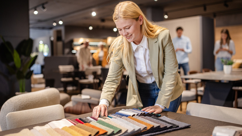 The person looks at a selection of fabric swatches