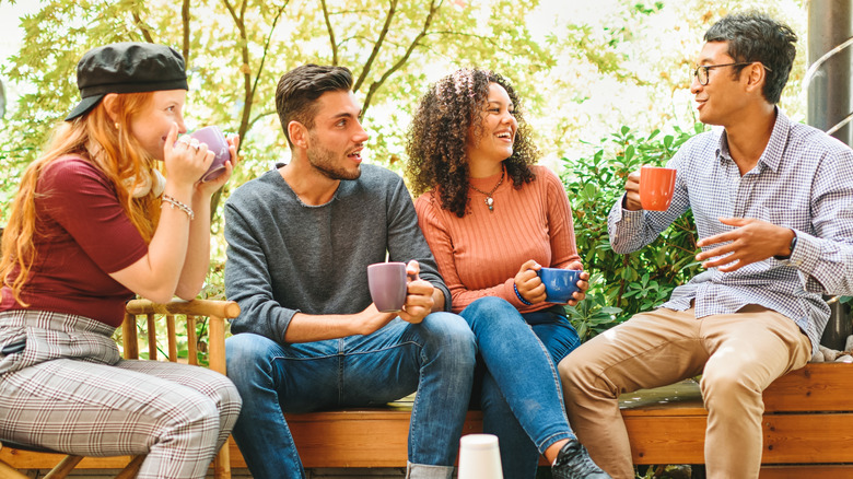Friends drinking from assorted mugs