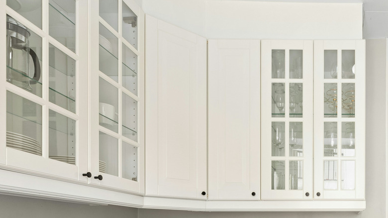 A close up of white narrow kitchen cabinets