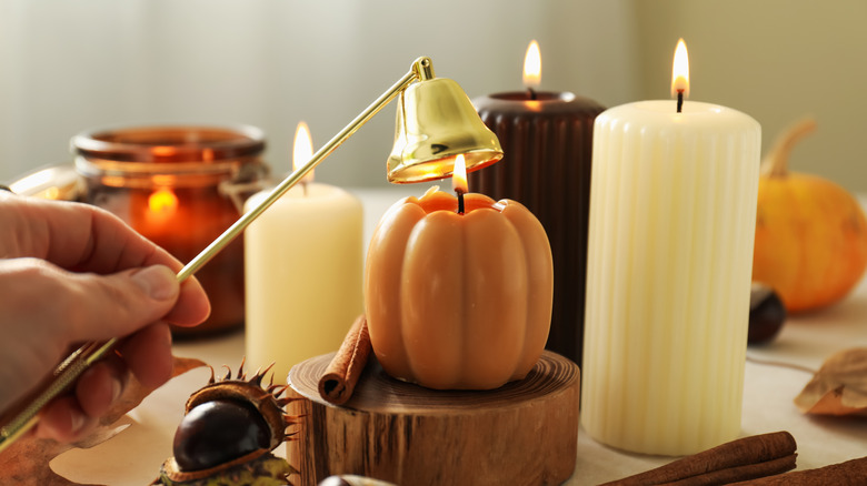 candles burning with a candle snuffer coming into frame