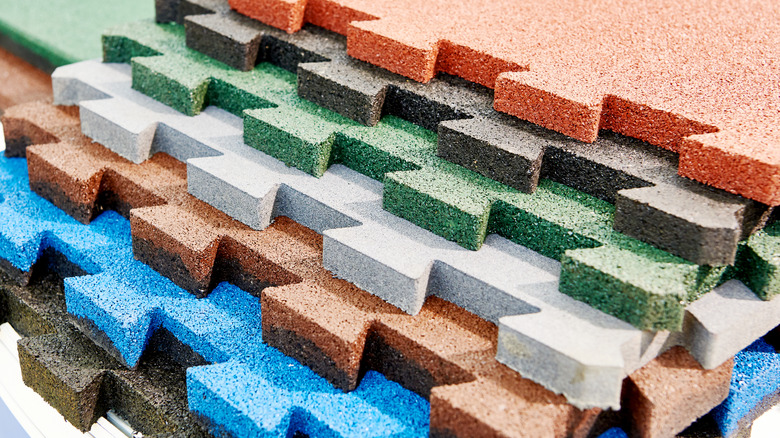 Stacked interlocking rubber floor tiles in various colors