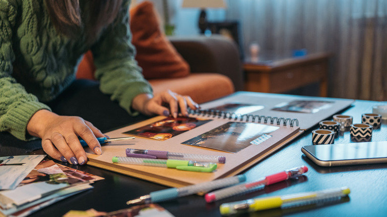 A person working with washi tape in a scrapbook