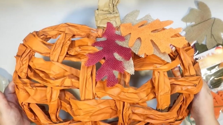 Woman showing off DIY pumpkin wreath