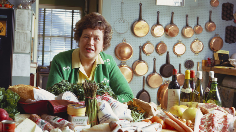 chef Julia Child in a kitchen full of cooking ingredients and utensils