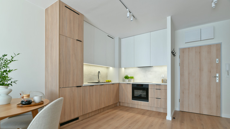 Photo of compact minimalist built-in scandinavian-style kitchen with appliances in oak and white with led lights
