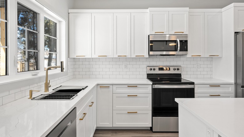 A modern kitchen with all white cabinets and countertops