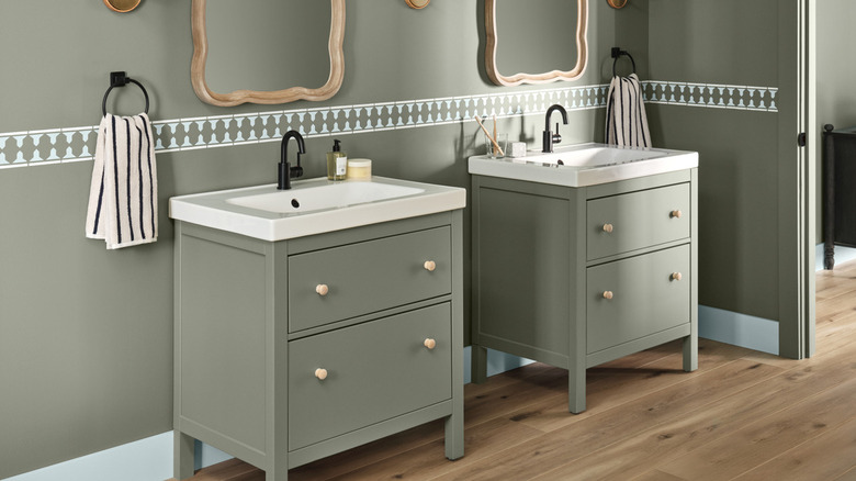 A bathroom with cabinets and walls painted in the same shade of Warm Eucaluptus from Valspar