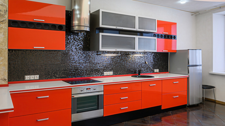 Empty, modern kitchen with red high-gloss cabinets