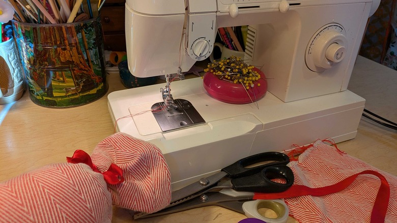 A candy pillow next to a sewing machine and fabric scraps