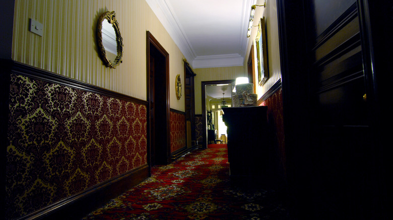 Dark carpet in a hallway with yellow walls and door frames painted black.