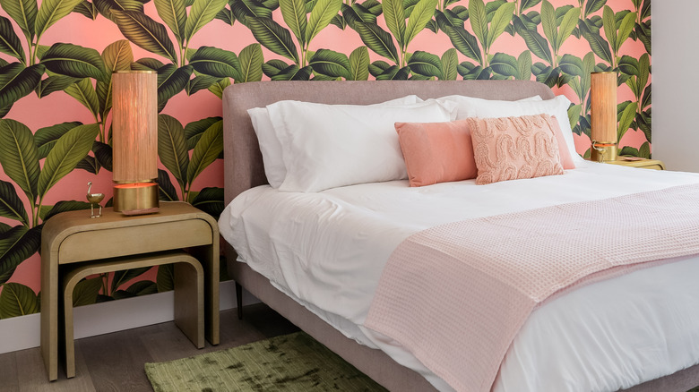 A bedroom with a bright, colorful wallpaper