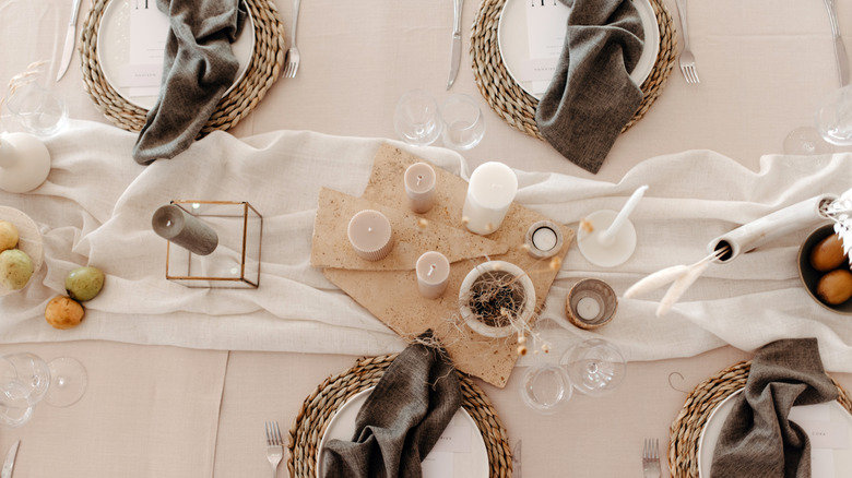 A white and gray table setting with candles.