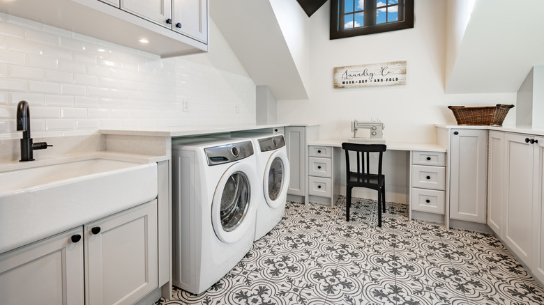 Modern laundry room with washing machine and dryer next to a sewing machine
