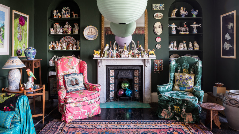 A dark-walled living room looks inviting with bright colors, lots of texture, and mismatching pieces.