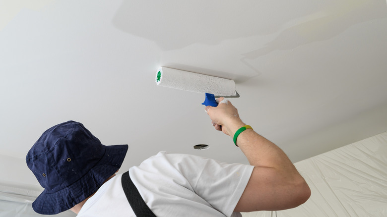 Person painting a ceiling with a roller