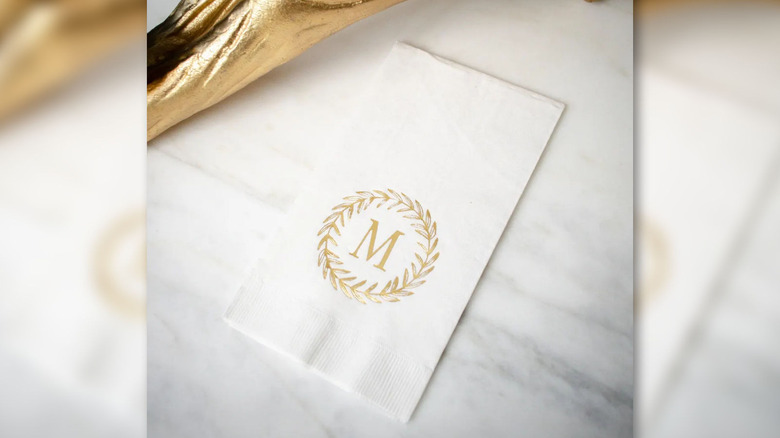 A monogrammed paper towel sitting on a marble counter