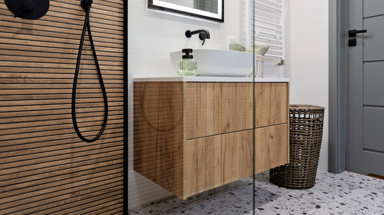 bathroom with wood panel strips on vanity and shower wall