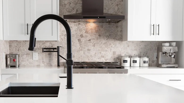 rough stone backsplash behind stove and range in kitchen