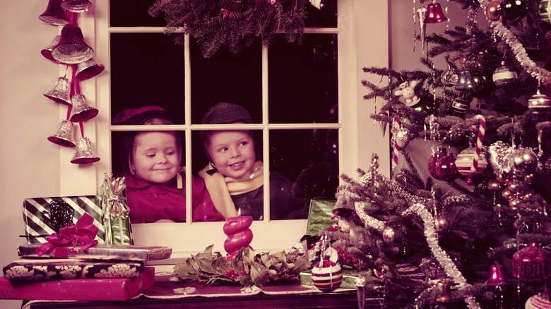 Vintage photo of kids looking through a window at a Christmas tree