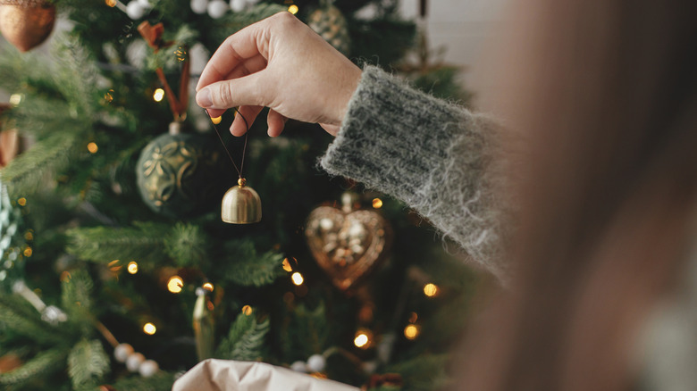 woman placing in a bell into her tree