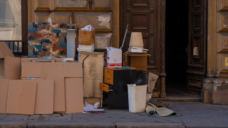 Discarded furniture and decor sitting out on a curb.