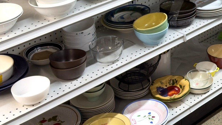 Secondhand bowls displayed on metal shelves inside a thrift store